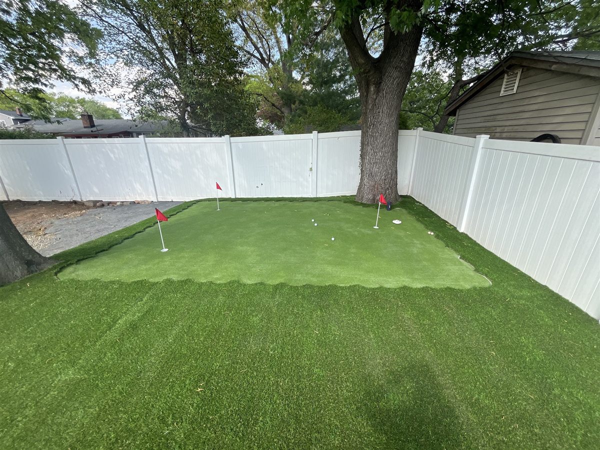 Backyard putting green with practice flags installed by Turf Boss Construction in New Jersey