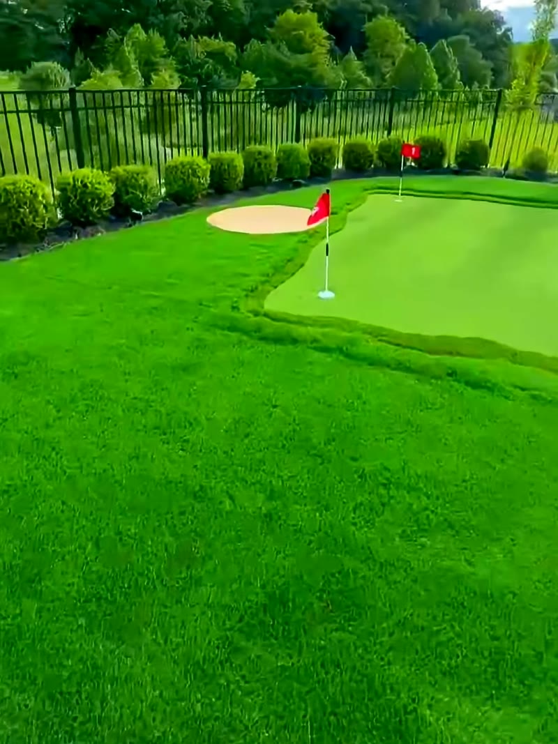 Contoured synthetic putting green with chipping bunker and two flag positions