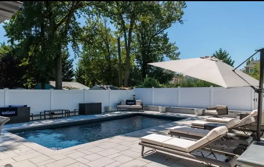 Pool patio with lounge furniture and umbrella