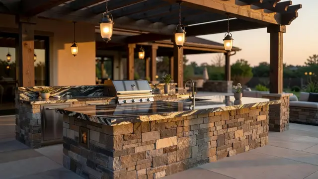 Outdoor kitchen with stone island under pergola